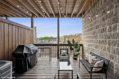 a view of balcony with wooden floor and outdoor seating