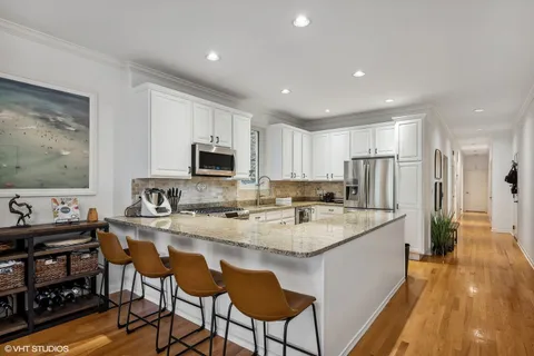 a kitchen with refrigerator and chairs