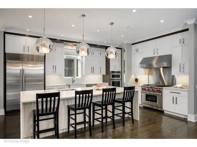 a kitchen with stainless steel appliances kitchen island granite countertop a stove a sink a refrigerator and a dining table