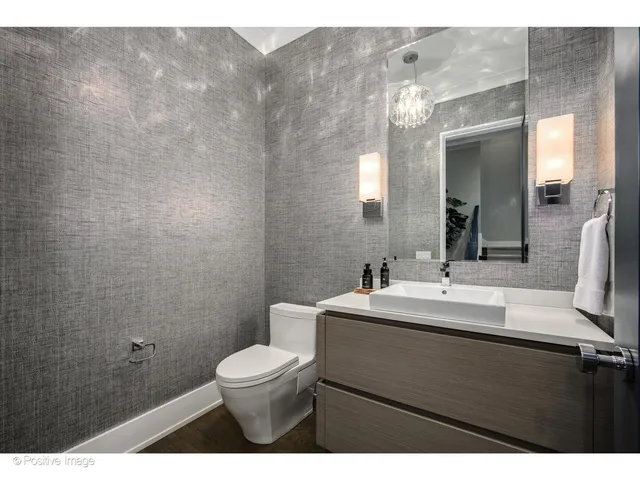 a bathroom with a toilet sink vanity and mirror