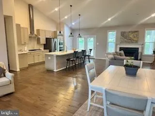 a large living room with stainless steel appliances kitchen island granite countertop furniture and a fireplace