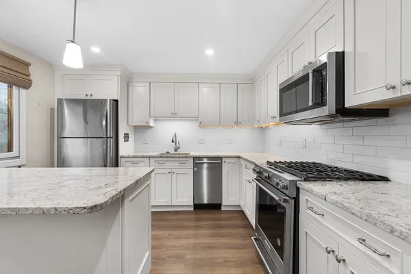 a kitchen with granite countertop stainless steel appliances and wooden cabinets