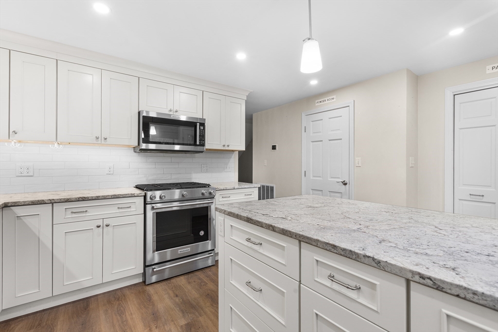 14 Williams Street, Unit C17 Danvers, MA 01923 - Photo 4 of 30 a kitchen with granite countertop a sink stainless steel appliances and white cabinets