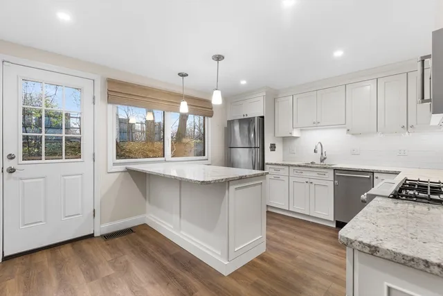a kitchen with stainless steel appliances granite countertop a stove a sink and a refrigerator
