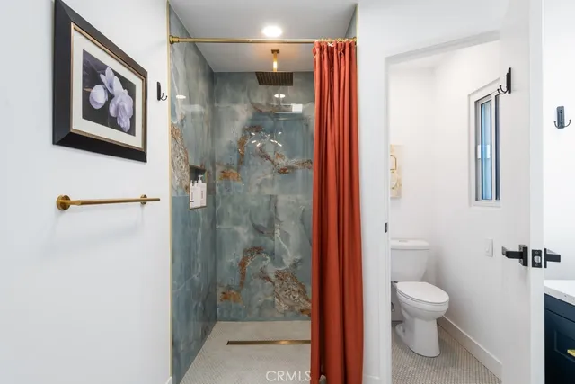 a bathroom with a granite countertop sink a toilet and shower
