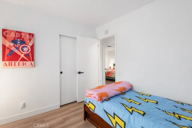 a bedroom with bed and a painting on the wall