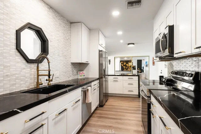 a kitchen with a sink stove and cabinets