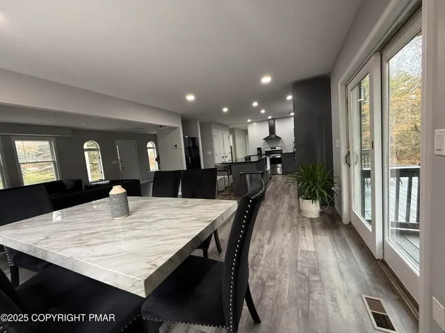 a kitchen with a dining table chairs and refrigerator