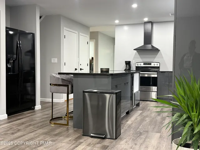 a kitchen with stainless steel appliances granite countertop a stove a sink and a refrigerator