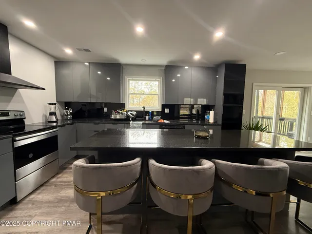 a kitchen with granite countertop white cabinets a sink and a stove
