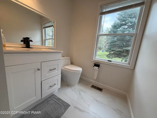 a bathroom with a toilet sink and window