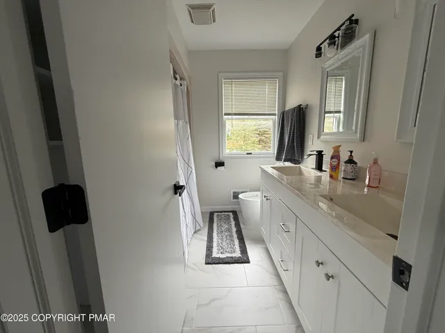 a bathroom with a granite countertop sink a mirror and a bathtub