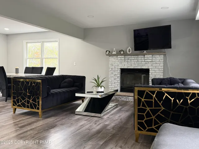 a living room with furniture a flat screen tv and a fireplace