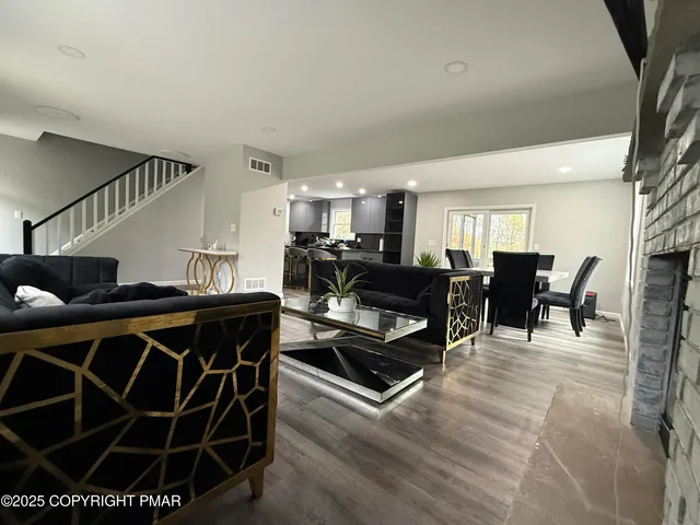 a living room with furniture a flat screen tv and a table