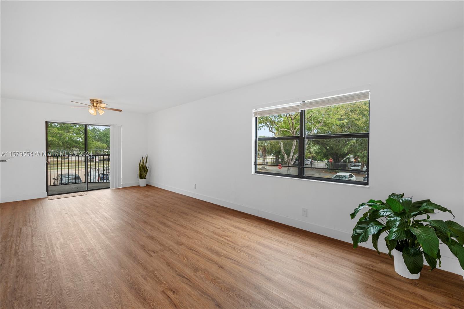 3252 Foxcroft Road, Unit 216 Miramar, FL 33025 - Photo 2 of 16 an empty room with wooden floor and windows