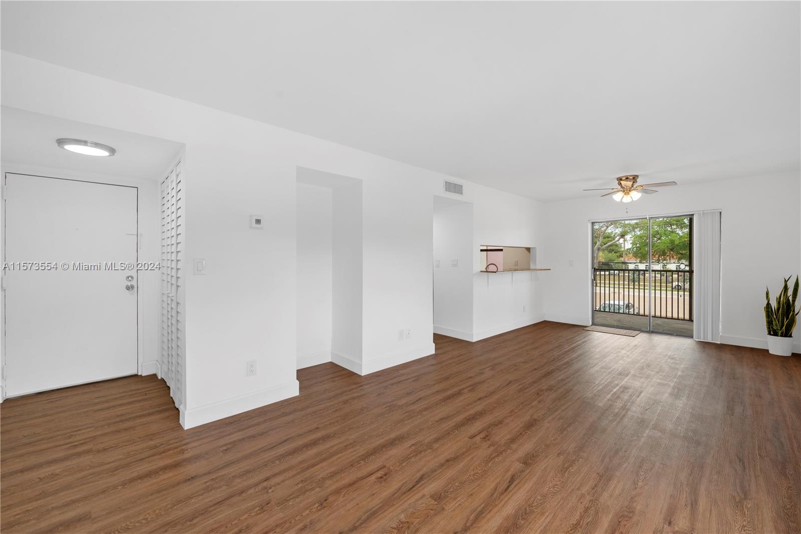 3252 Foxcroft Road, Unit 216 Miramar, FL 33025 - Photo 3 of 16 an empty room with wooden floor and windows