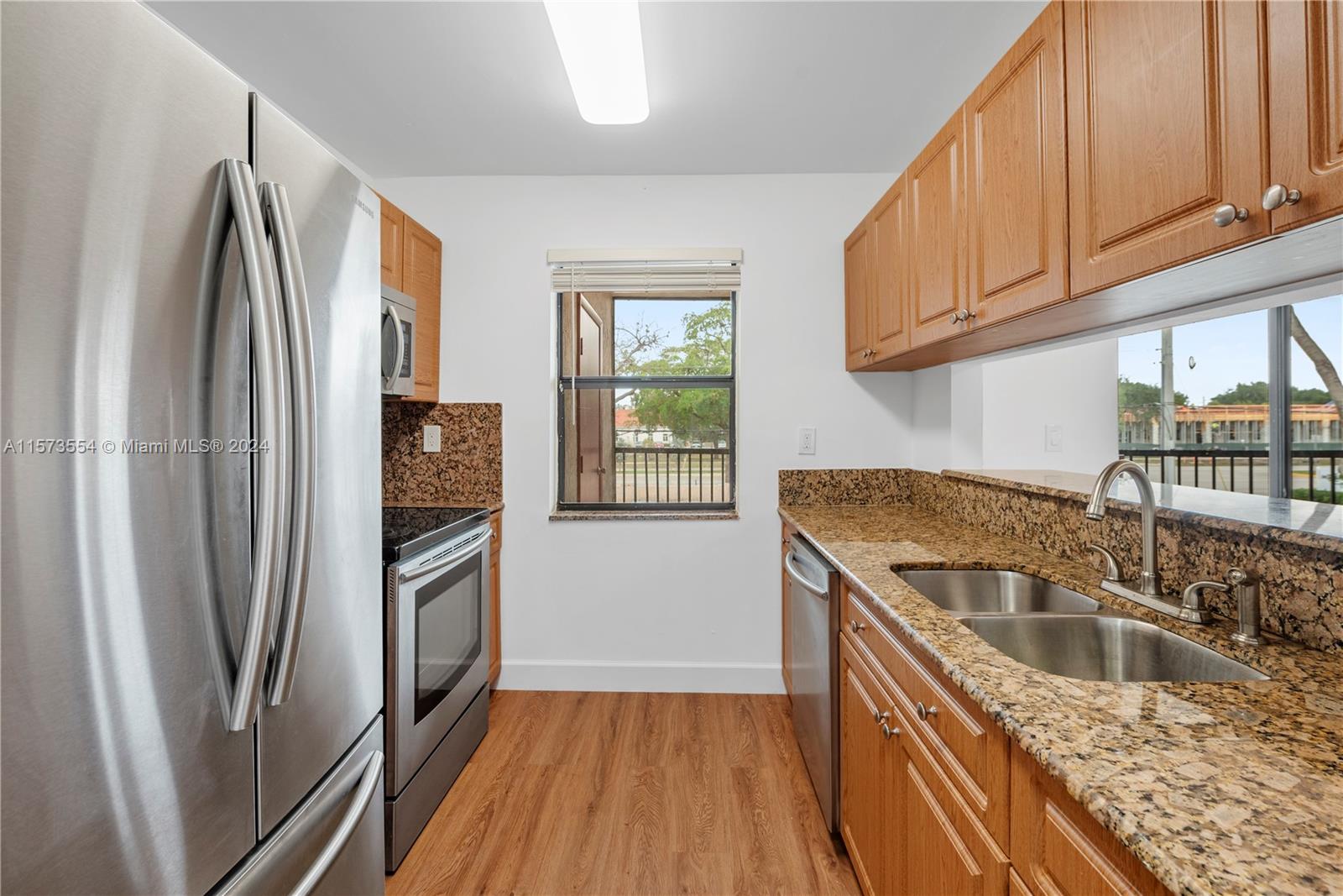 3252 Foxcroft Road, Unit 216 Miramar, FL 33025 - Photo 6 of 16 a kitchen with granite countertop a refrigerator and a sink