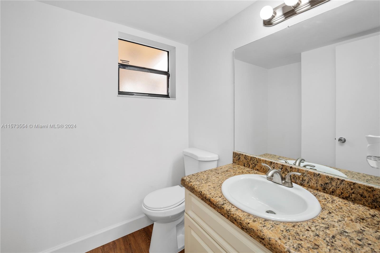 3252 Foxcroft Road, Unit 216 Miramar, FL 33025 - Photo 7 of 16 a bathroom with a granite countertop sink and a mirror