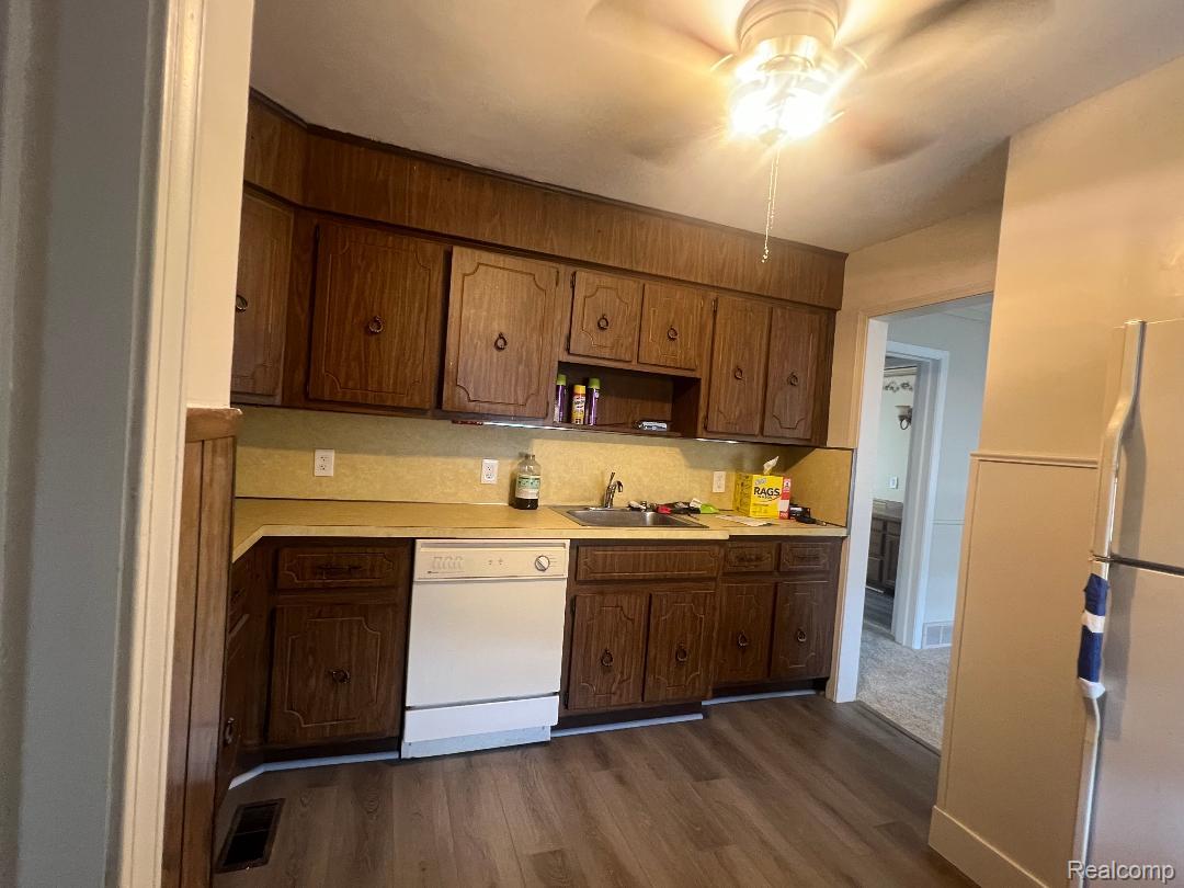 149 Roth Boulevard Clawson, MI 48017 - Photo 5 of 20 Kitchen featuring wood-finish cabinetry, a single basin sink, a dishwasher, and wood-finish flooring