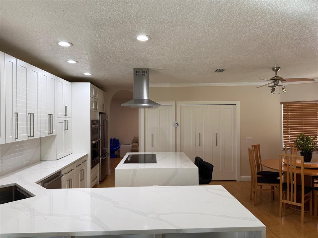 3290 Southwest 131st Terrace Davie, FL 33330 - Photo 5 of 46 a living room with stainless steel appliances kitchen island granite countertop a sink a dining table and chairs with wooden floor