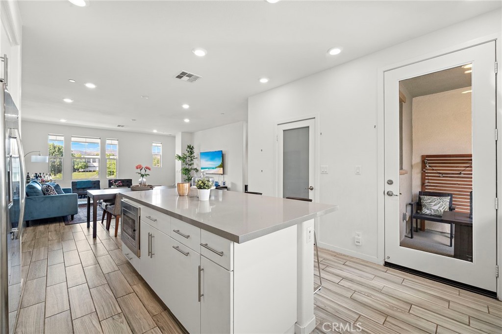 144 Paramount Irvine, CA 92618 - Photo 4 of 43 a large kitchen with kitchen island a sink a counter top space and cabinets