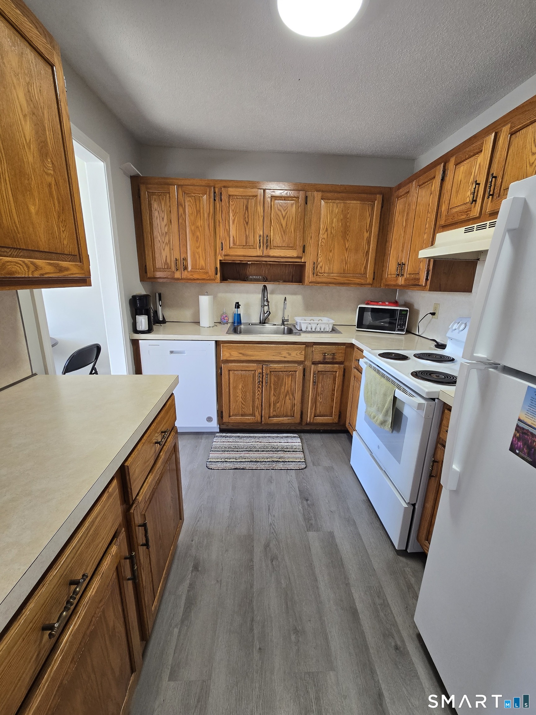 177 Lisle Street, Unit 5 Torrington, CT 06790 - Photo 10 of 18 a kitchen with wooden cabinets and stainless steel appliances