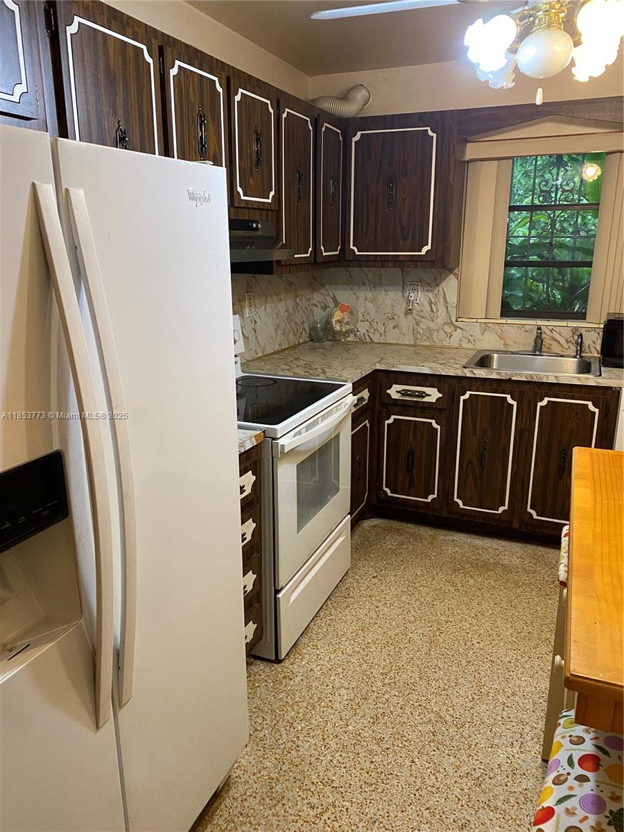 8120 Southwest 10th Terrace Miami, FL 33144 - Photo 8 of 12 a kitchen with stainless steel appliances granite countertop a stove a sink and a microwave