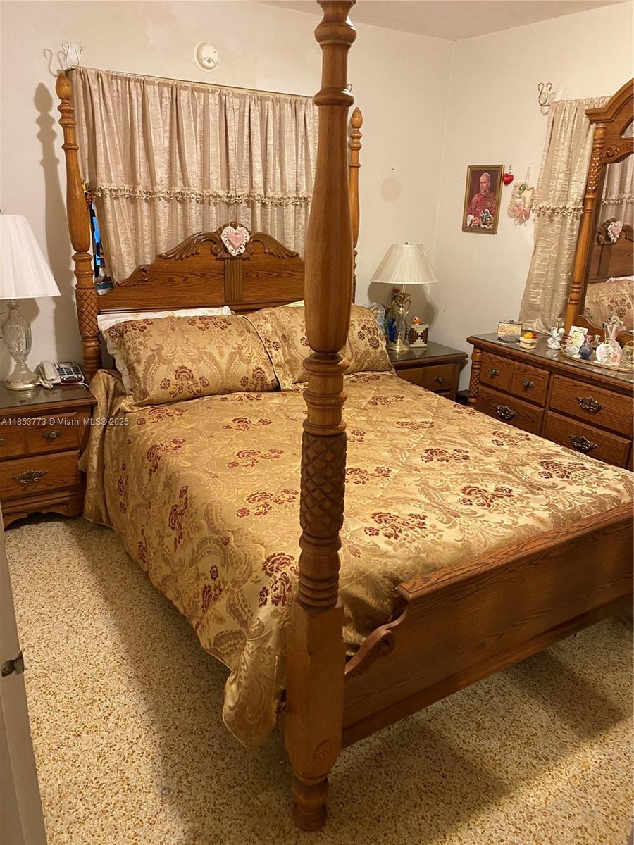 8120 Southwest 10th Terrace Miami, FL 33144 - Photo 10 of 12 a bed sitting in a bedroom next to a window