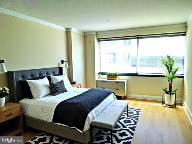 a bedroom with a bed and a table with potted plants