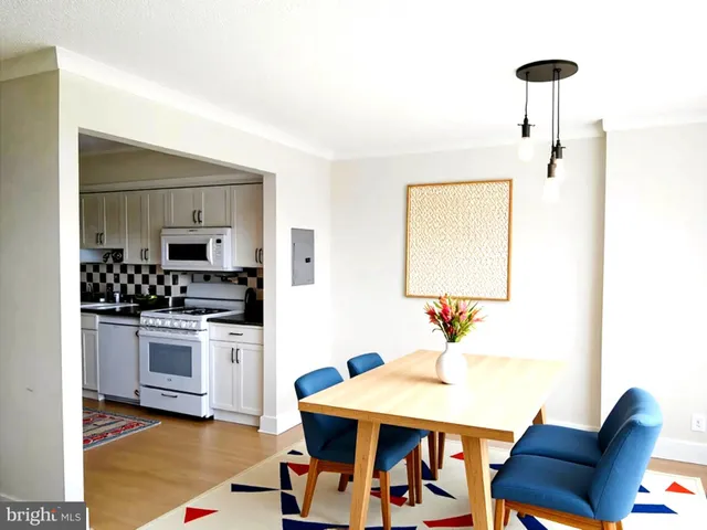 a kitchen with stainless steel appliances kitchen island a table and chairs in it
