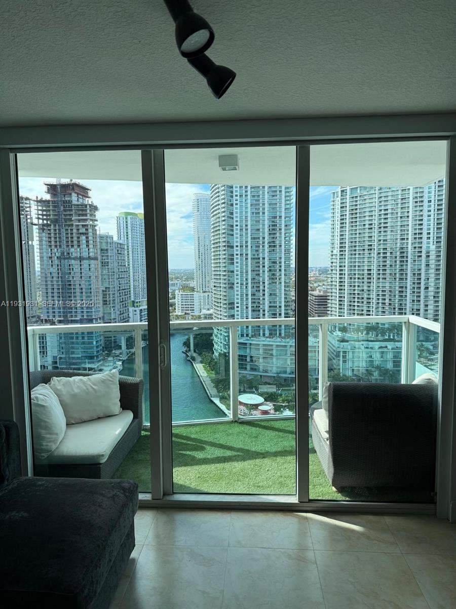 31 Southeast 5th Street, Unit 2907 Miami, FL 33131 - Photo 1 of 38 a living room with furniture and a floor to ceiling window
