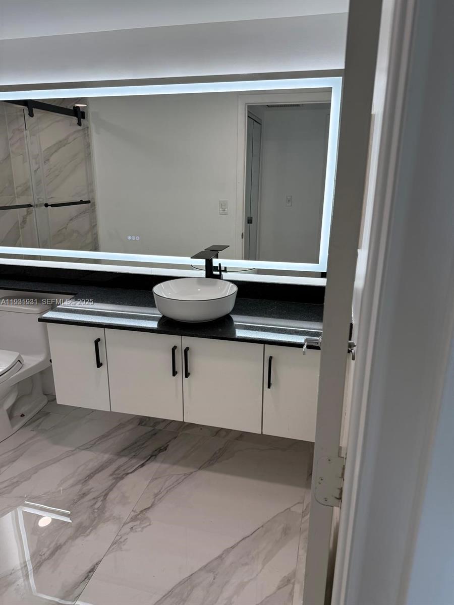 31 Southeast 5th Street, Unit 2907 Miami, FL 33131 - Photo 12 of 38 a bathroom with a sink and mirror