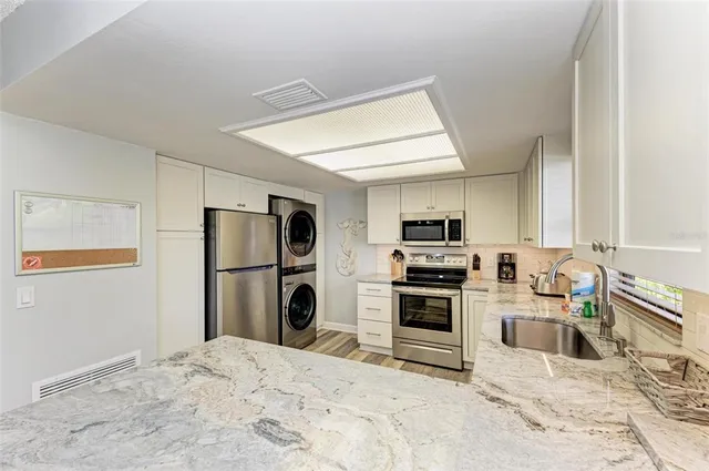 a kitchen with a refrigerator and a stove top oven