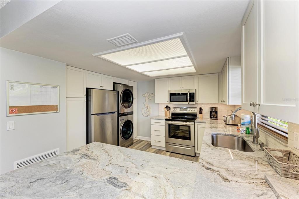 304 74th Street, Unit B Holmes Beach, FL 34217 - Photo 11 of 34 a kitchen with a refrigerator and a stove top oven