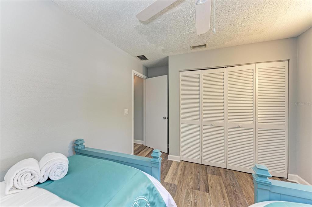 304 74th Street, Unit B Holmes Beach, FL 34217 - Photo 16 of 34 a bedroom with a bed and wooden floor