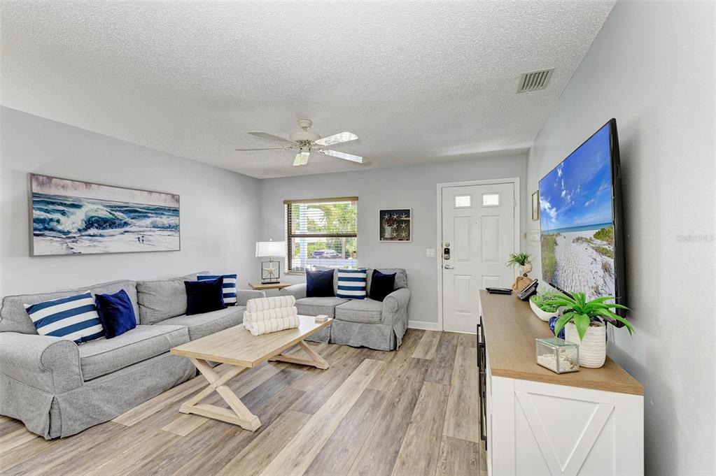 304 74th Street, Unit B Holmes Beach, FL 34217 - Photo 18 of 34 a living room with furniture and a chandelier