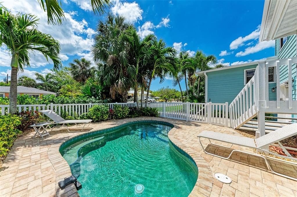 304 74th Street, Unit B Holmes Beach, FL 34217 - Photo 26 of 34 a view of a swimming pool with a patio and a garden