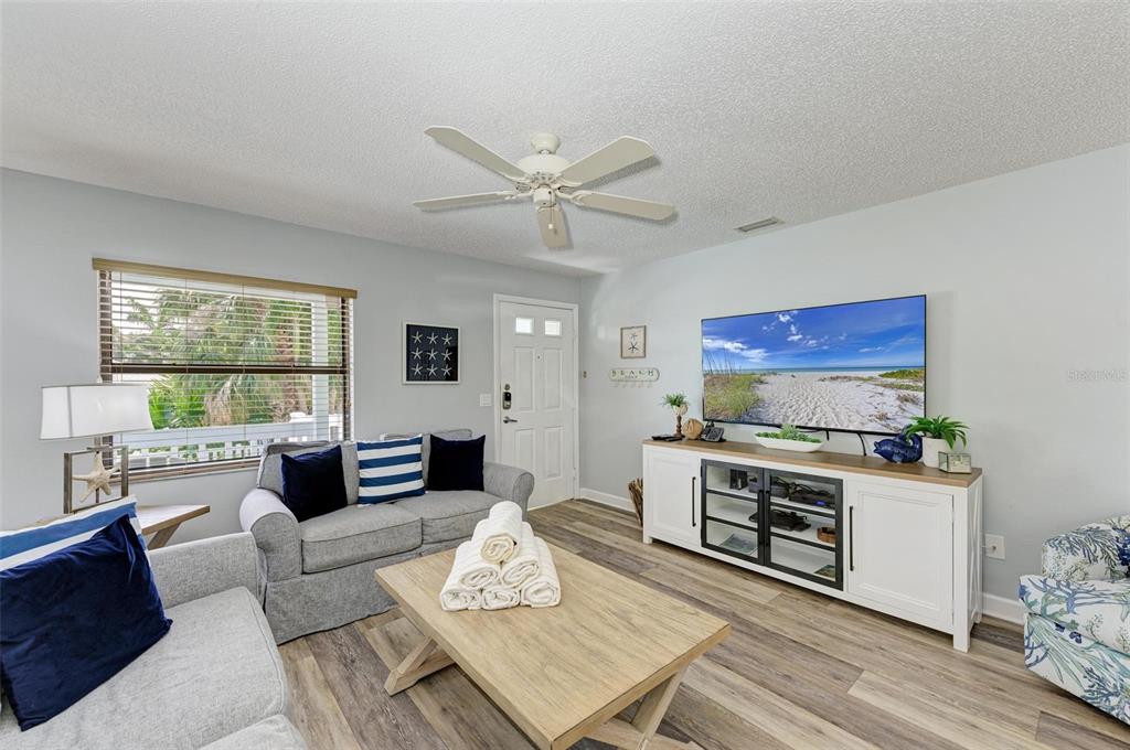 304 74th Street, Unit B Holmes Beach, FL 34217 - Photo 4 of 34 a living room with furniture a fireplace and a table