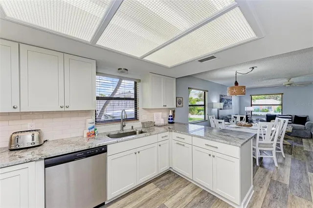 a kitchen with a sink window and cabinets