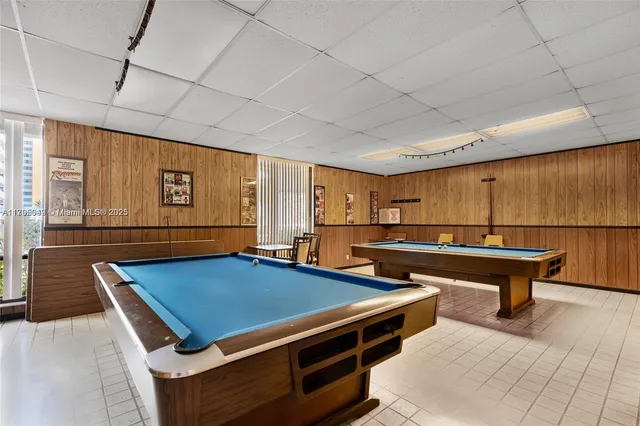a room with pool table and windows