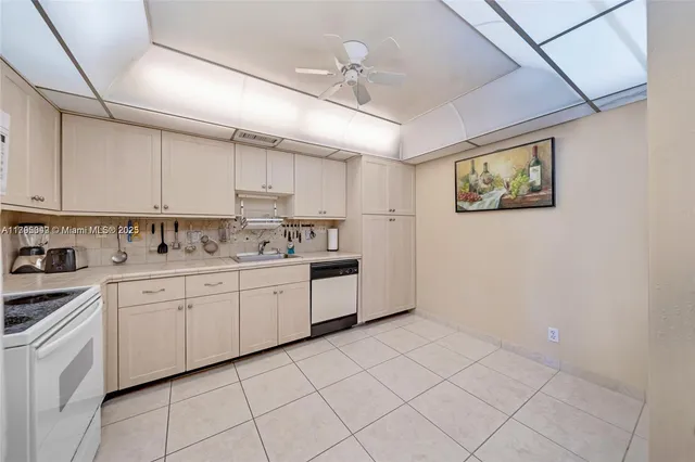 a kitchen with granite countertop white cabinets white stainless steel appliances with a sink and dishwasher