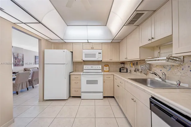 a kitchen with a sink a refrigerator and cabinets