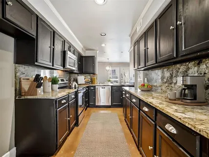 a kitchen with stainless steel appliances granite countertop a stove top oven a sink dishwasher and cabinets