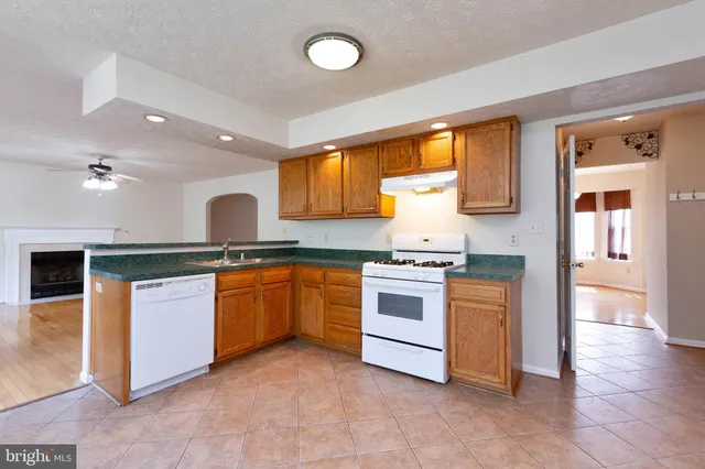 a kitchen with granite countertop a stove top oven sink and cabinets
