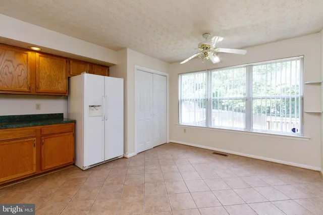 a view of a kitchen with an empty room and a window