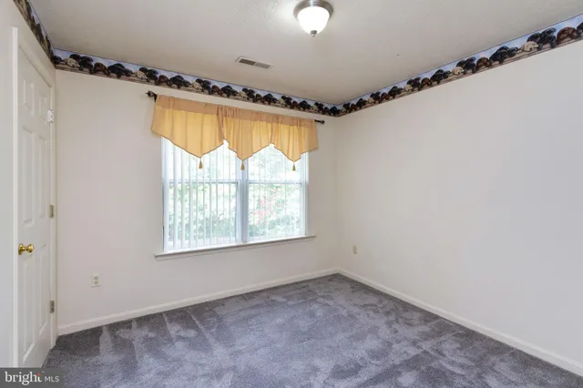 en empty room with windows and a chandelier