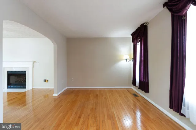 a view of empty room with wooden floor and fireplace