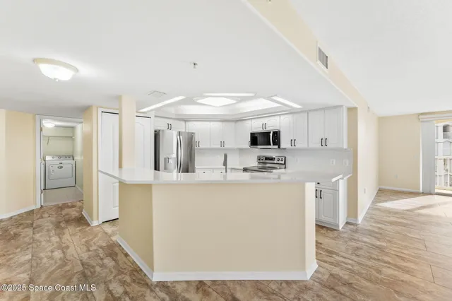 a kitchen with stainless steel appliances granite countertop a refrigerator sink and white cabinets