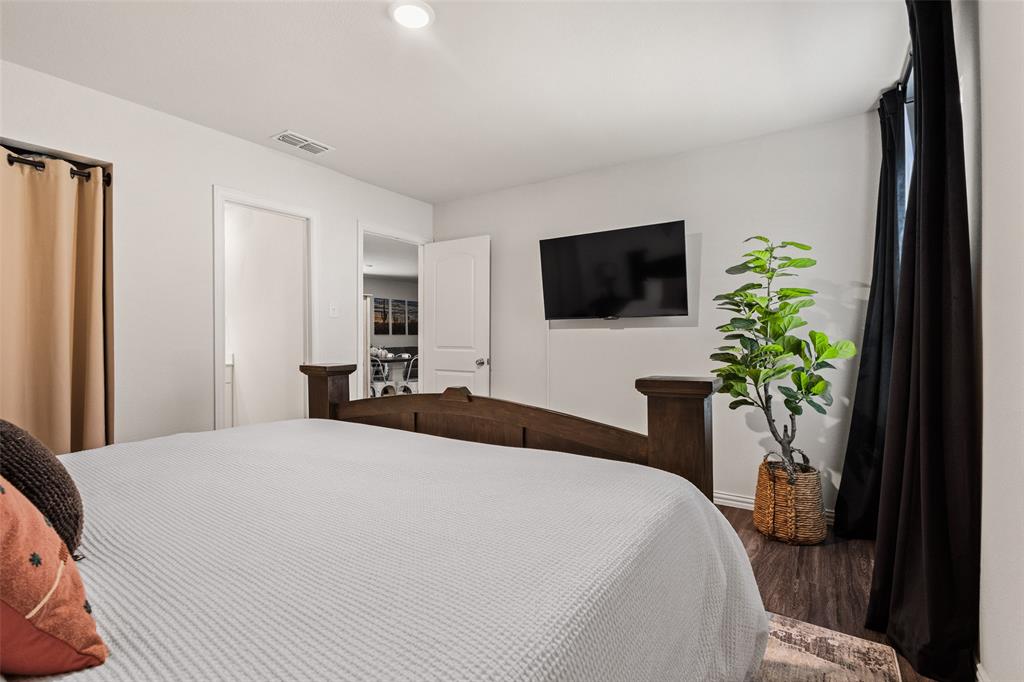 921 West 9th Street Bonham, TX 75418 - Photo 8 of 24 a bedroom with a bed and a flat screen tv