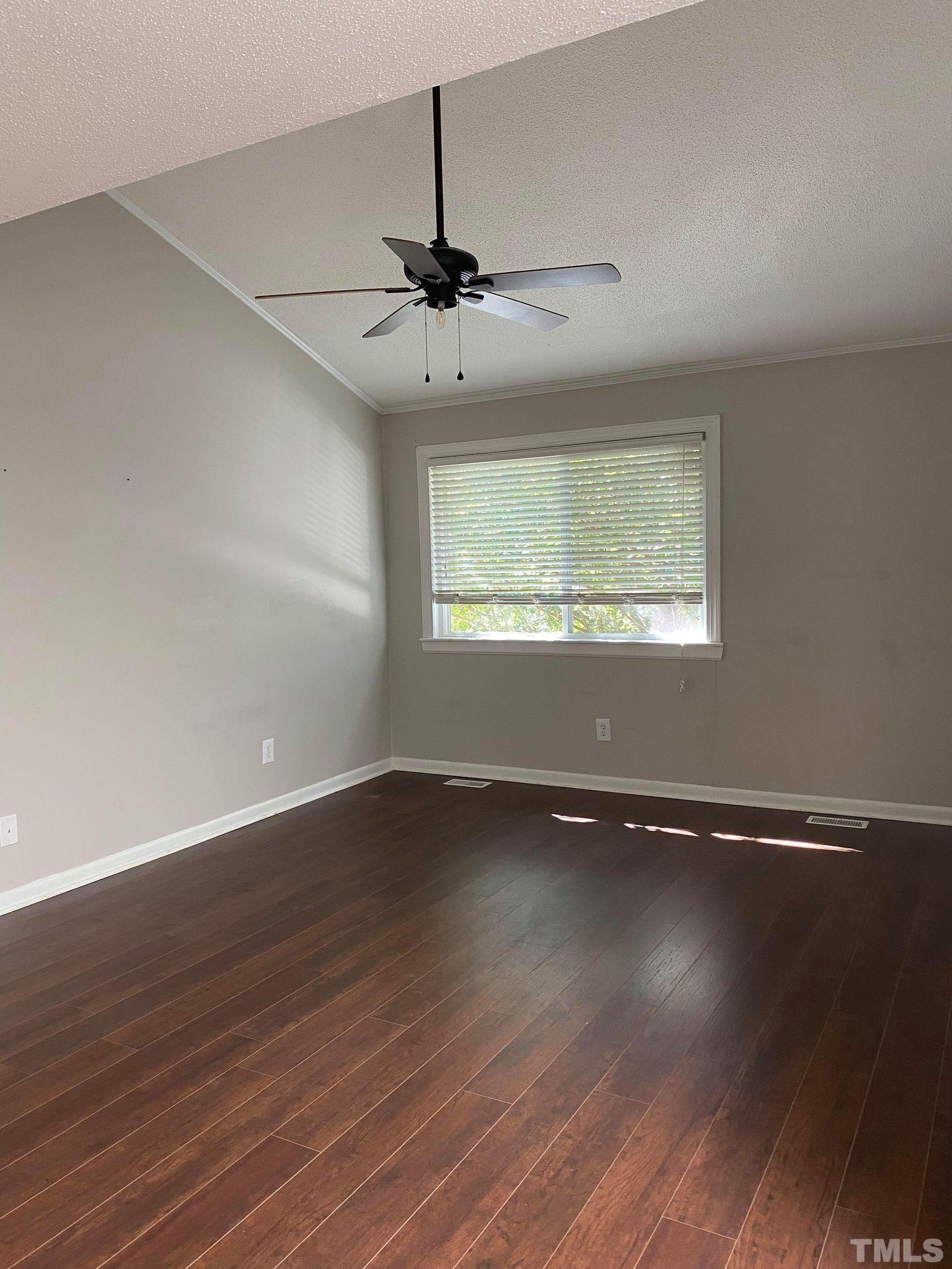 4347 Lake Ridge Drive, Unit 10 Raleigh, NC 27604 - Photo 22 of 30 an empty room with wooden floor chandelier fan and windows